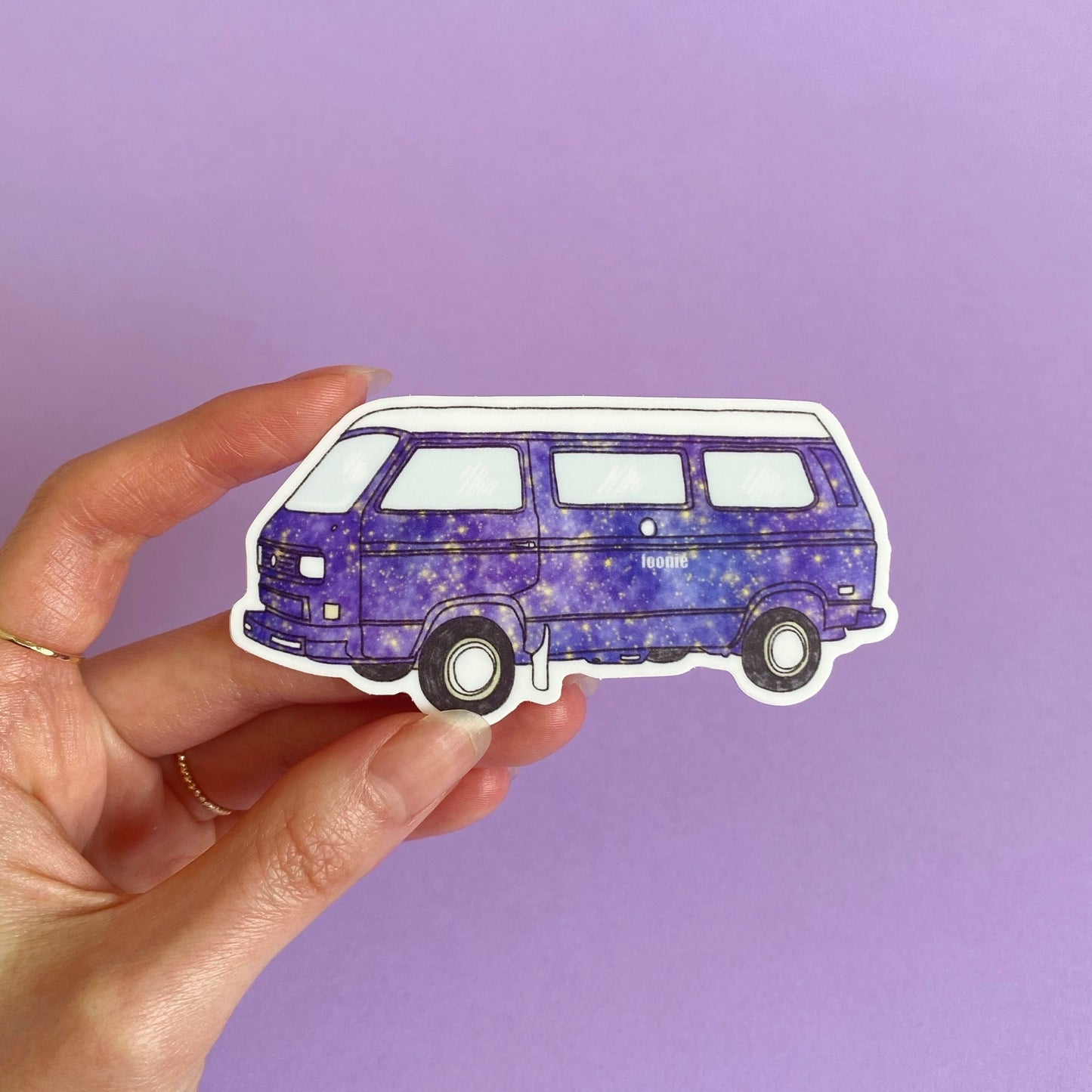 A hand holding a die cut sticker of a camper van by foonie