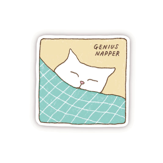 A cute sticker with the illustration of a white cat sleeping in bed with the text “Genius Napper”