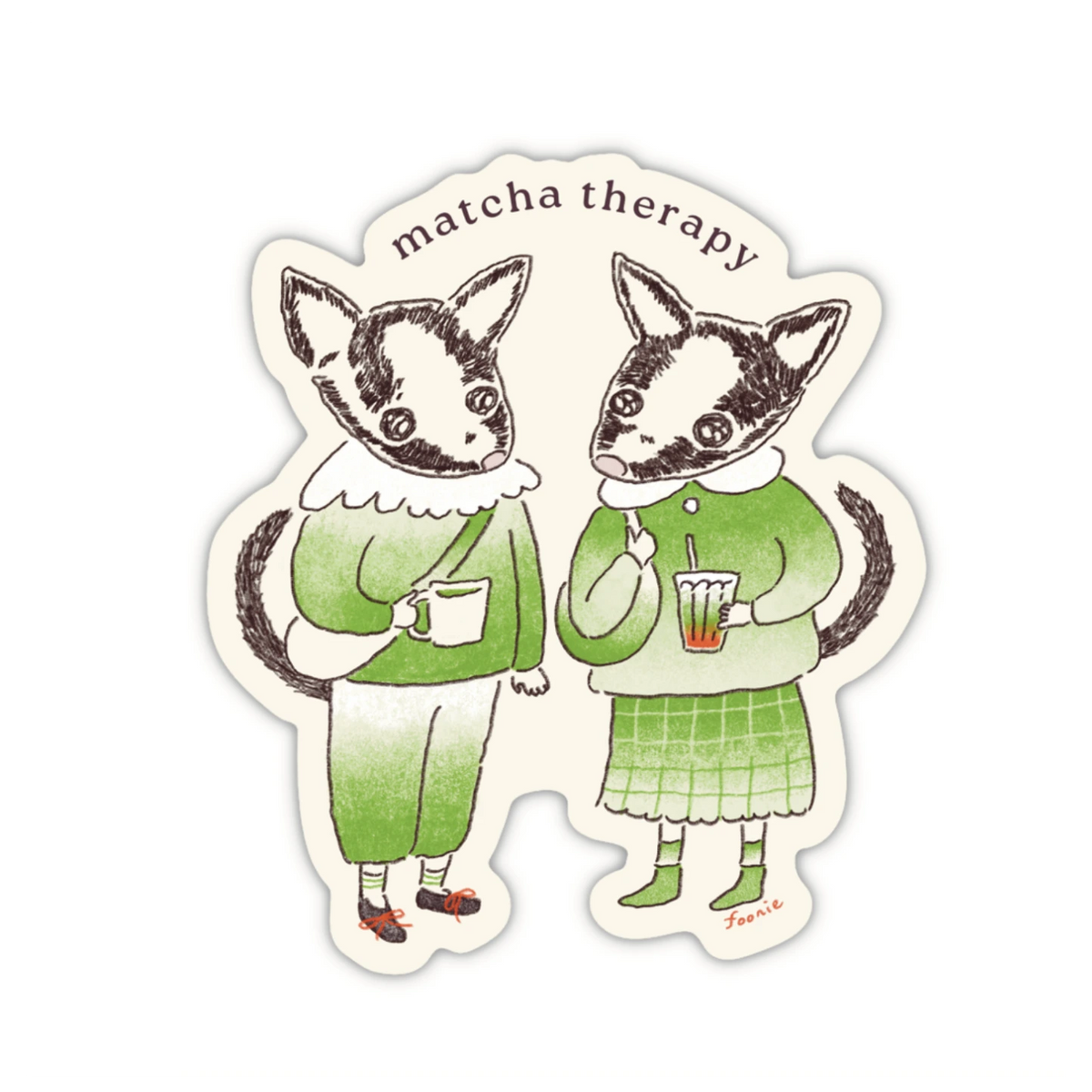 A die-cut sticker with an illustration of two animals dressed in matcha inspired outfits and holding matcha drinks, with the text 'matcha therapy' above them.