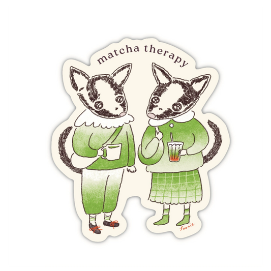 A die-cut sticker with an illustration of two animals dressed in matcha inspired outfits and holding matcha drinks, with the text 'matcha therapy' above them.