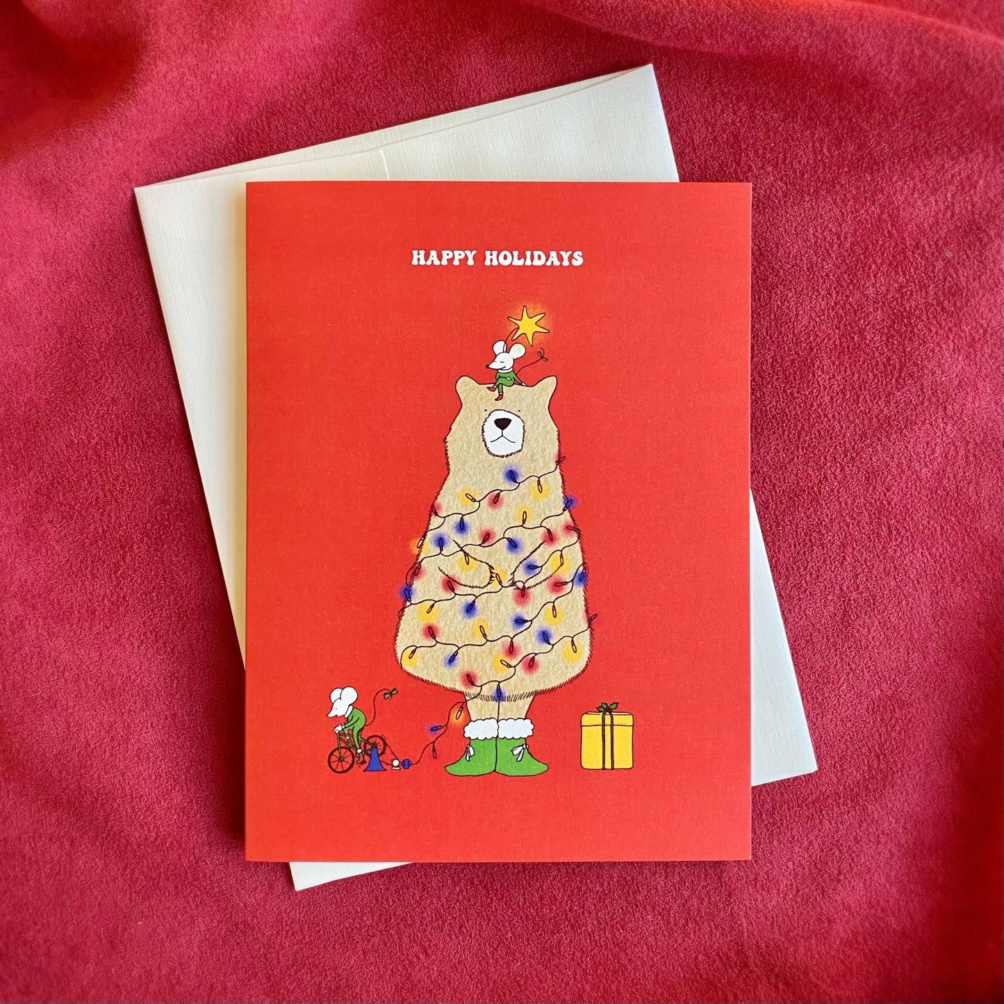 Cute Christmas Card with the text “not a creature was stirring, Merry Christmas” and the illustration of a bear as a Christmas tree and two mice on a red background