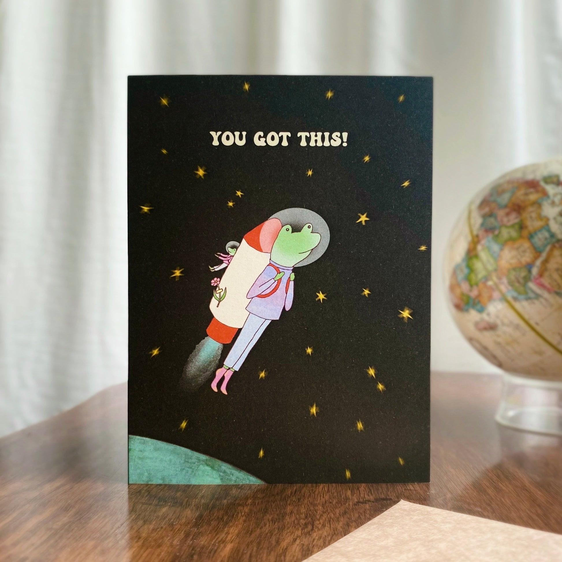 Inspiring encouragement card with the illustration of a frog as an astronaut heading to the universe with a rocket machine on his back