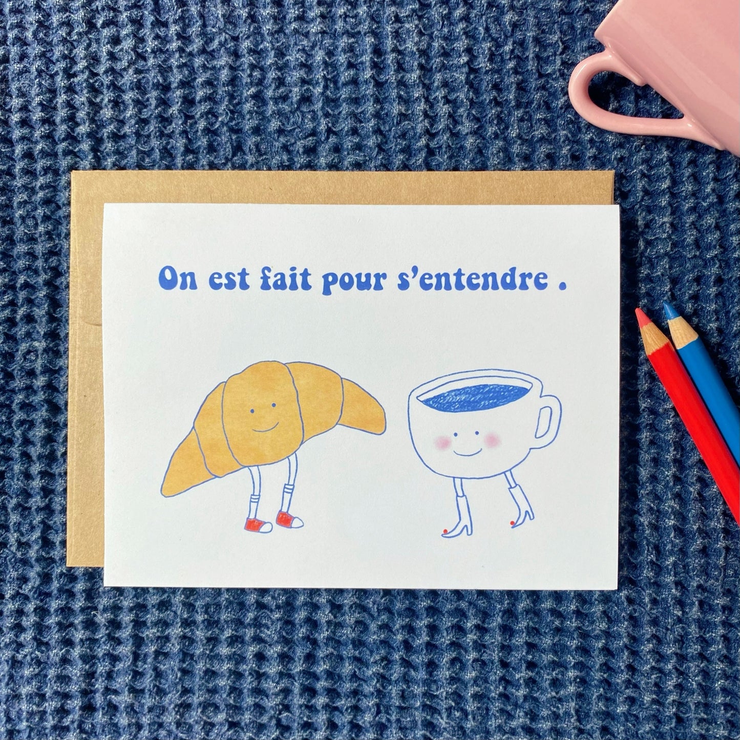 cute French just because card with the illustration of a croissant and coffee cup with legs and faces
